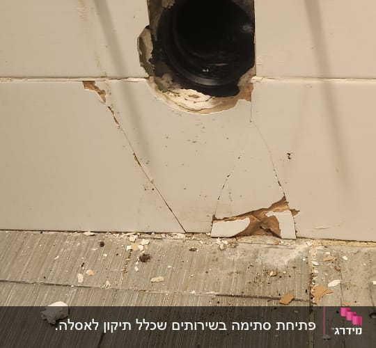 צינור מים חשוף עם מפתח ברגים על הרצפה
